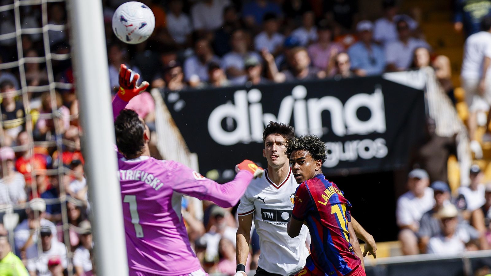 El portero del Valencia Stole Dimitrievski ve como marca el jugador del Barcelona Lamine Yamal.