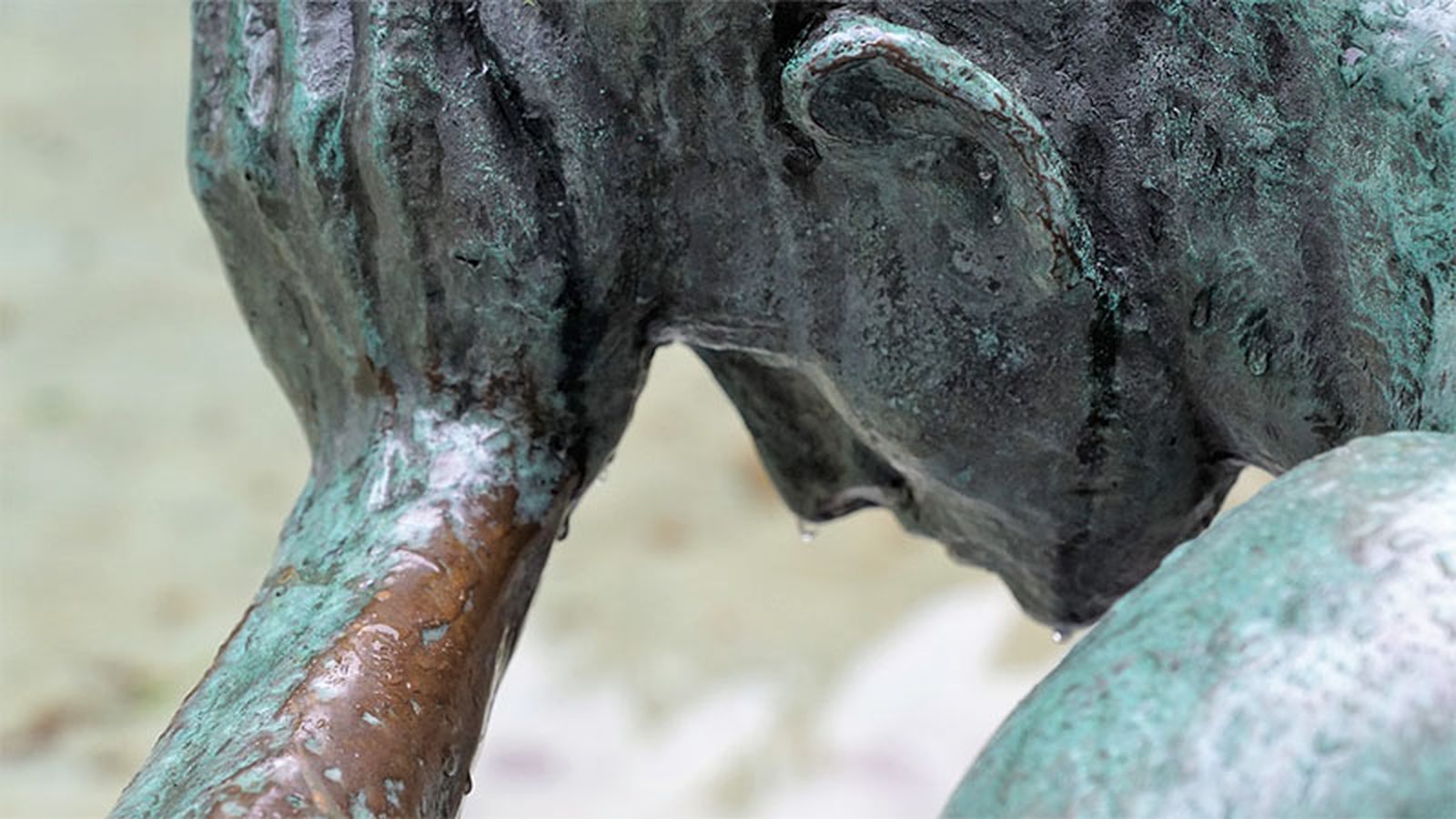 Imagen de la cabeza de una estatua con la mano apoyada en la frente