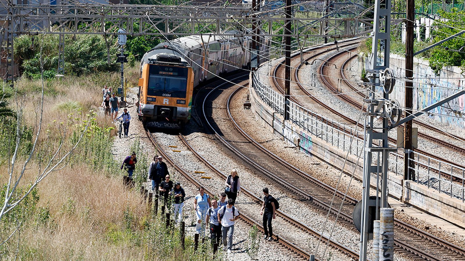 Gente caminando por la via del tren durante el apagón